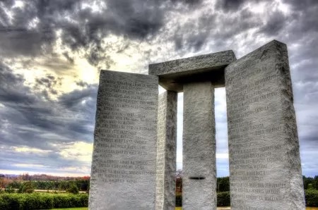 The Georgia Guidestones monument in Elbert County, Georgia, featuring engraved granite slabs under a stormy sky—capturing the mystery, symbolism, and conspiracy theories surrounding the site.
