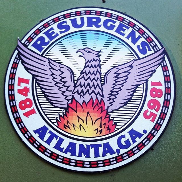 The official seal of Atlanta, Georgia, featuring a phoenix rising from flames with wings spread, the word “Resurgens” above it, and the years 1847 and 1865 flanking the bird—symbolizing the city’s destruction and rebirth after the Civil War.
